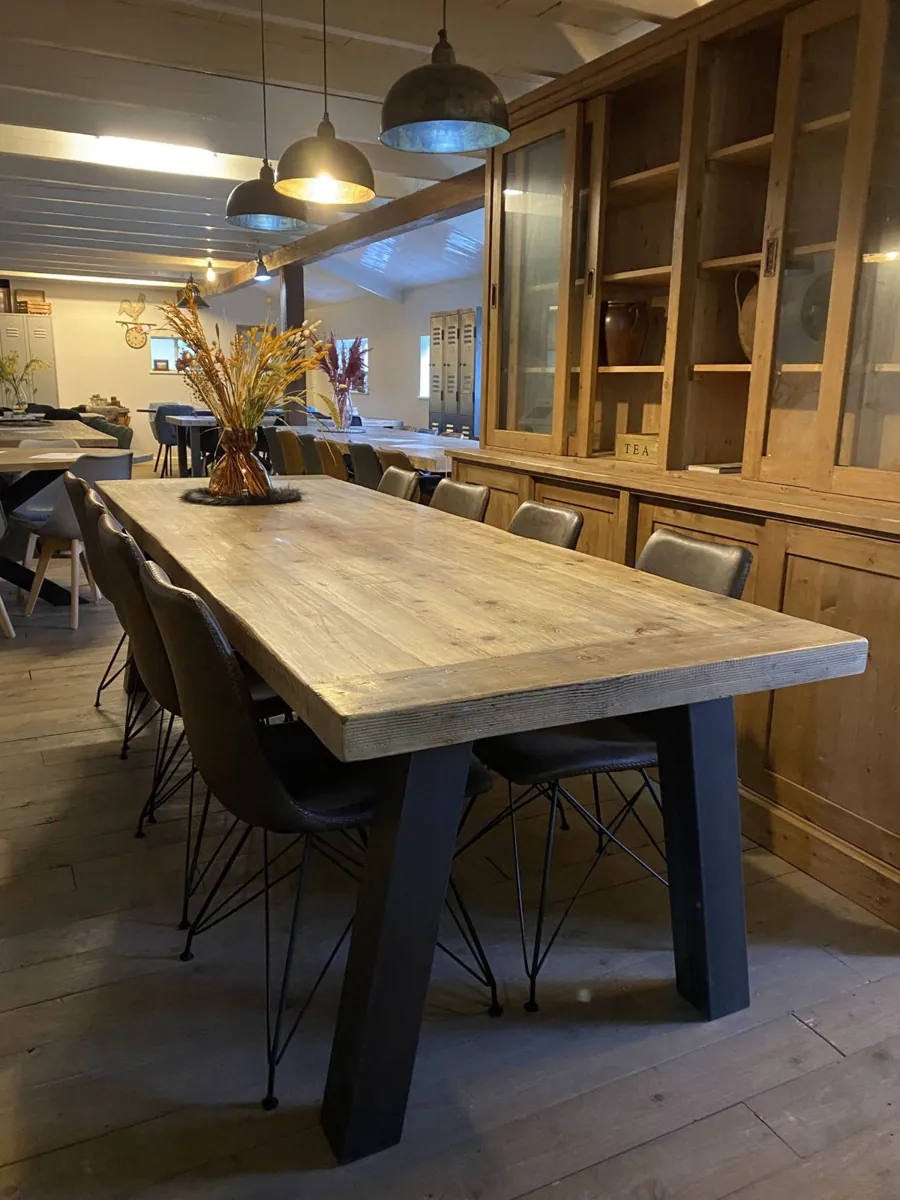 Lange massief houten eettafel met stalen poten in onze showroom in Veghel